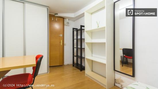 Cálida habitación con estantería en piso compartido, Malasaña - MADRID