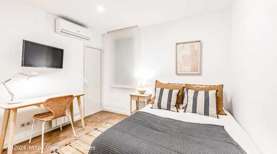 Dormitorio 2: cama doble con escritorio y TV/baño compartido. - BARCELONA